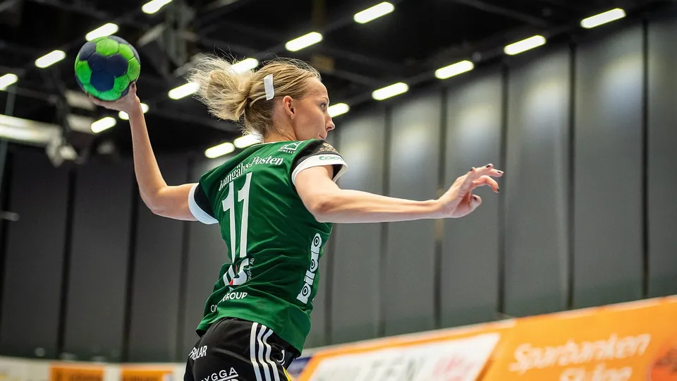 A handball player jumping to shoot